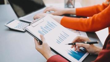 mano de mujer de negocios trabajando con computadora portátil, tableta y teléfono inteligente en la oficina moderna con diagrama de icono virtual en la oficina moderna a la luz de la mañana video