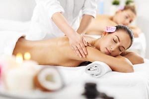 Two beautiful women getting massage in spa photo