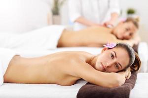 Two beautiful women getting massage in spa photo