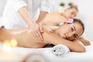 Two beautiful women getting massage in spa photo