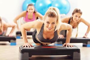 Group of smiling people doing push-ups photo