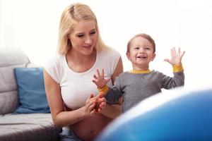 Young Happy Pregnant woman playing with son photo