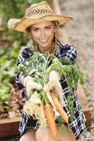 Adult woman picking vegetables from garden photo