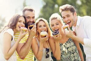 Group of friends eating donuts outdoors photo