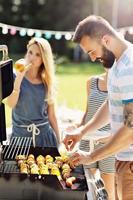 Friends having barbecue party in backyard photo