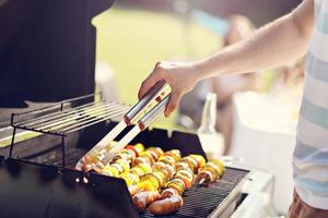 Friends having barbecue party in backyard photo