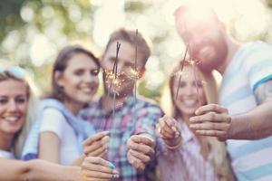 Group of friends having fun with sparklers photo