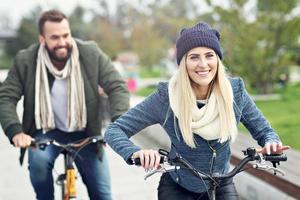 pareja joven montando en bicicleta y divirtiéndose en la ciudad foto