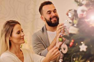 Happy couple decorating christmas tree photo