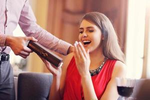 Romantic couple dating in restaurant and giving present photo