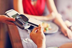 People paying in restaurant by credit card reader photo