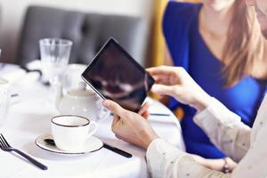 Two Businesspeople Meeting For Lunch and using tablet In Restaurant photo