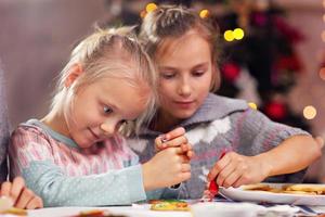 Happy little sisters preparing Christmas biscuits photo