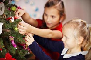 Children decorating Christmas tree photo