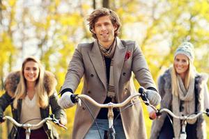 Group of friends on bikes in forest during fall time photo