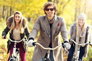 Group of friends on bikes in forest during fall time photo