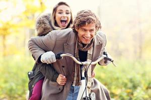 pareja feliz en bicicleta en el bosque durante el otoño foto