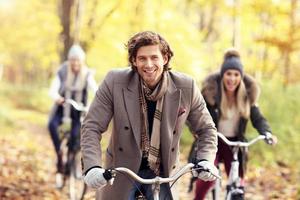 grupo de amigos en bicicleta en el bosque durante el otoño foto