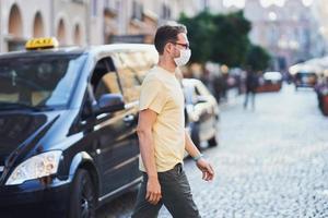 Adult man wearing a mask while walking in the city photo