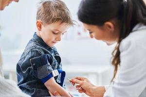 Little boy having blood sample drawn in a lab photo