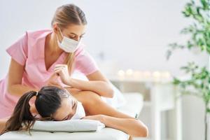 Adult woman in mask during relaxing massage in spa photo