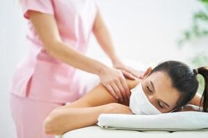 Adult woman in mask during relaxing massage in spa photo