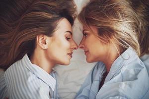 Two young girlfriends on the bed photo