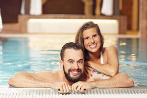 pareja feliz relajándose en el spa de la piscina foto