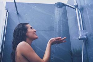 mujer adulta bajo la ducha en el baño foto