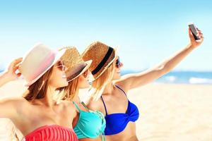 grupo de amigos tomando selfie en la playa foto