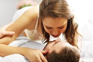 Young couple kissing in bed photo