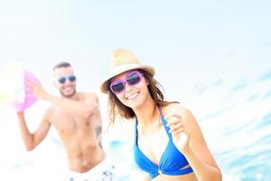 Young couple playing with a ball at the beach photo