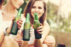 Happy group of friends drinking beer outdoors photo