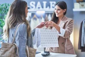 mujer vendedora y compradora en tienda de ropa foto