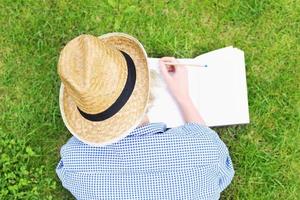 mujer tomando notas sobre la hierba foto