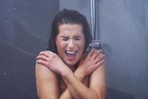 Adult woman under the shower in bathroom photo