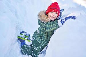 Happy kid having fun during winter snow photo