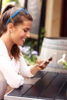 Happy woman using smartphone in cafe photo