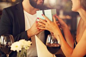 Romantic couple with present in restaurant photo