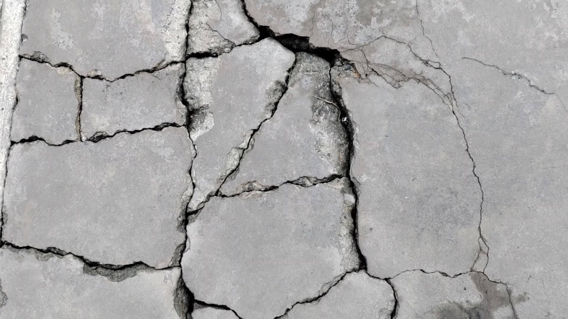 Cracked concrete ground broken at floor or street road from bad