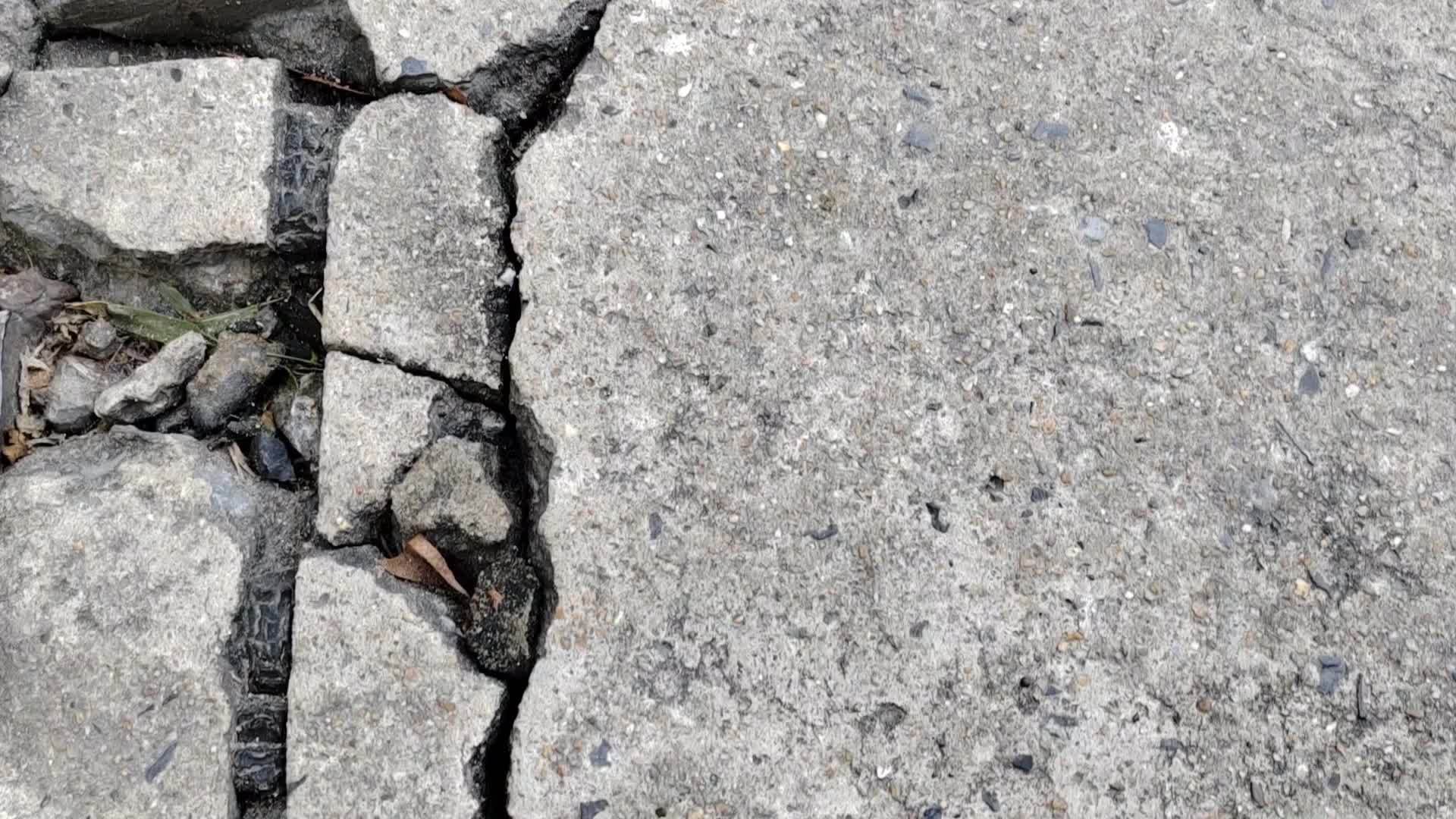 Cracked concrete ground broken at floor or street road from bad