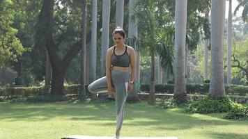 vídeo de uma mulher indiana praticando ioga na pose da árvore. video