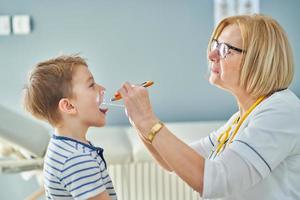 médico pediatra que examina a los niños pequeños en la clínica foto