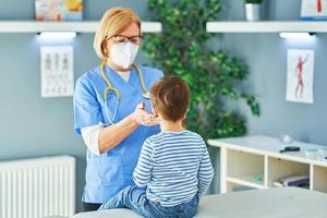 Pediatrician doctor examining little kids in clinic photo