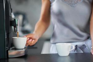 Nice woman making coffee in the kitchen photo