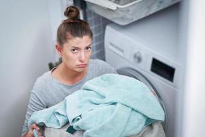 Picture of young woman making laundry work photo