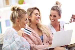 tres hermosas mujeres jóvenes comprando en línea foto