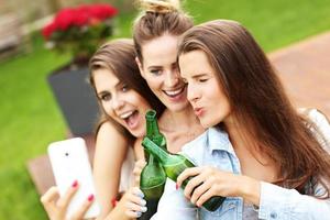 Happy group of friends drinking beer outdoors photo