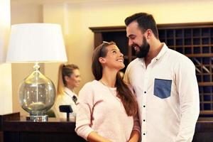 Couple at reception desk in hotel photo