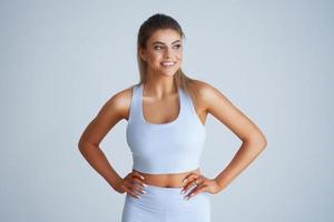 Adult beautiful woman working out over light background photo